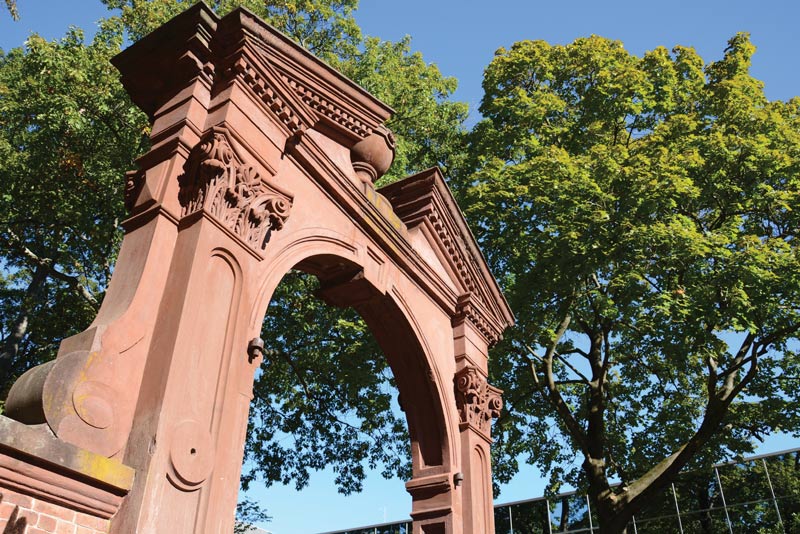 Ramapo Arch on a bright day with blue skies and green trees in the background