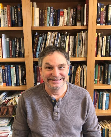 Professor Jason Hecht in front of books