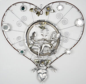 A metal heart. In the center is a circle with a man and woman clad in leaves.