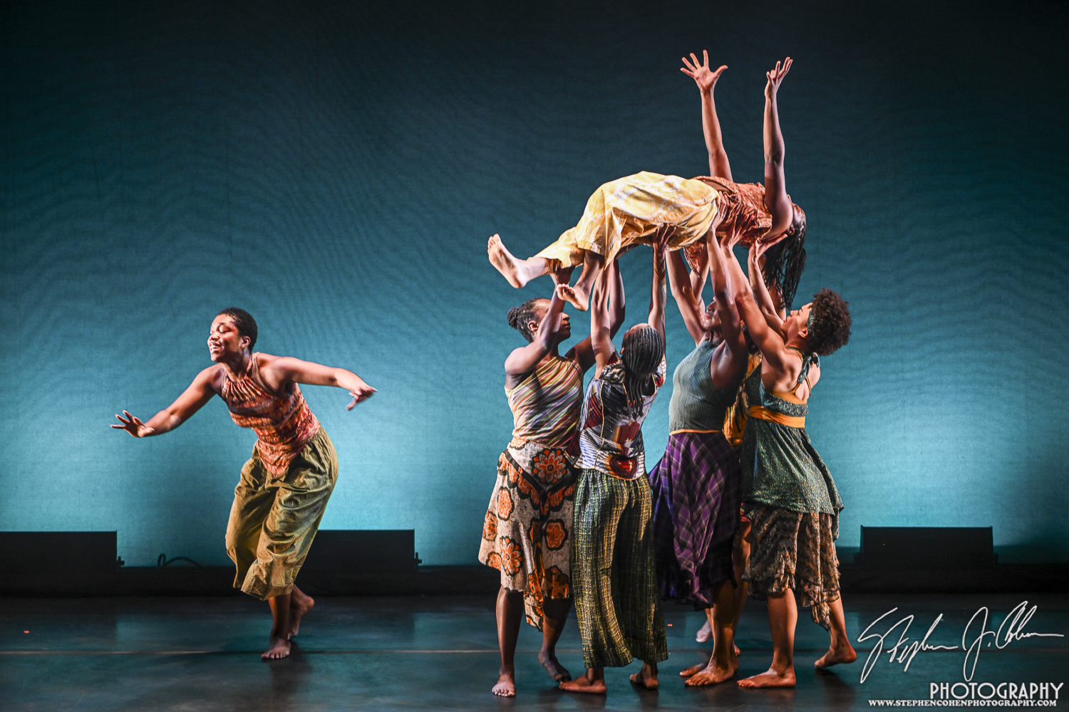 4 Dancers lifting someone, one dancer out in front.