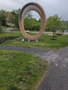 A sculpture of metal and light arranged into a tall oval.