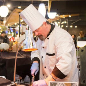 Catering staff wearing a chefs while preparing food