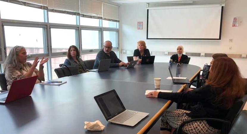 Faculty and staff sitting around a conference table at a Digital Humanities Experiential Learning Conference - 2024