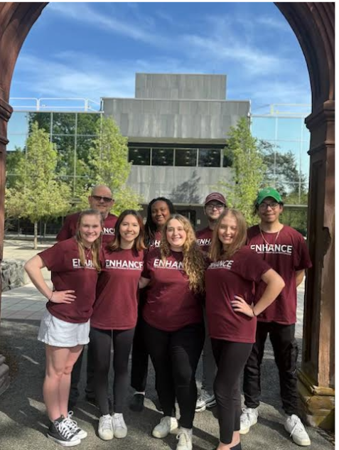 Eight ENHANCE Peer Mentors standing under the Arch.