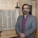 Gross Center Director Jacob Labendz with the Torah on display at the Center.