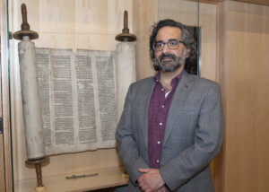Gross Center Director Jacob Labendz with the Torah on display at the Center.