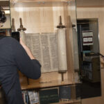 Two Ramapo students taking pictures of the Torah with their cell phones.