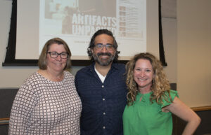 Three people in front of a projector screen