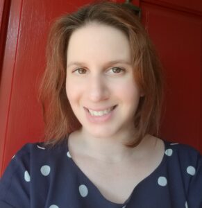 Headshot of Dr. Adina Newman in a blue shirt with large white pockadots.