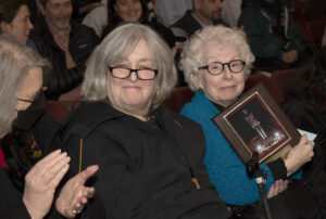 Yvonne Mannheimer-Lorber holding a plaque from the Holocaust rededication and sitting next to her daughter Kim Lorber.
