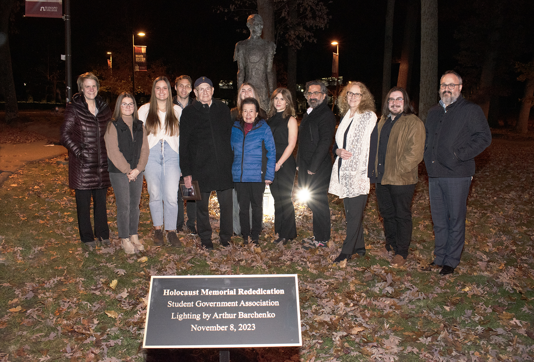 Ramapo Students lighting candles at the base of a statue