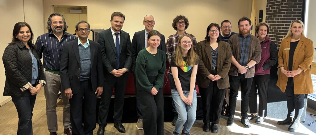 Two rows of people standing and smiling for the camera. 
