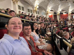 Students sitting in a fancy, European opera house.