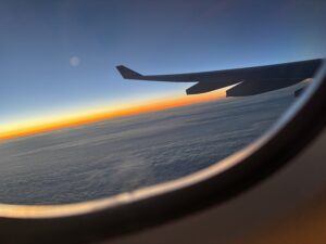 Sunset from a plane window with visible wing.