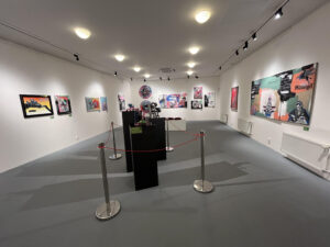 Large white room with colorful paintings on the walls.