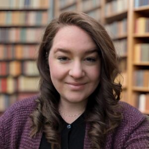 Headshot of Angela West with a library in the background.