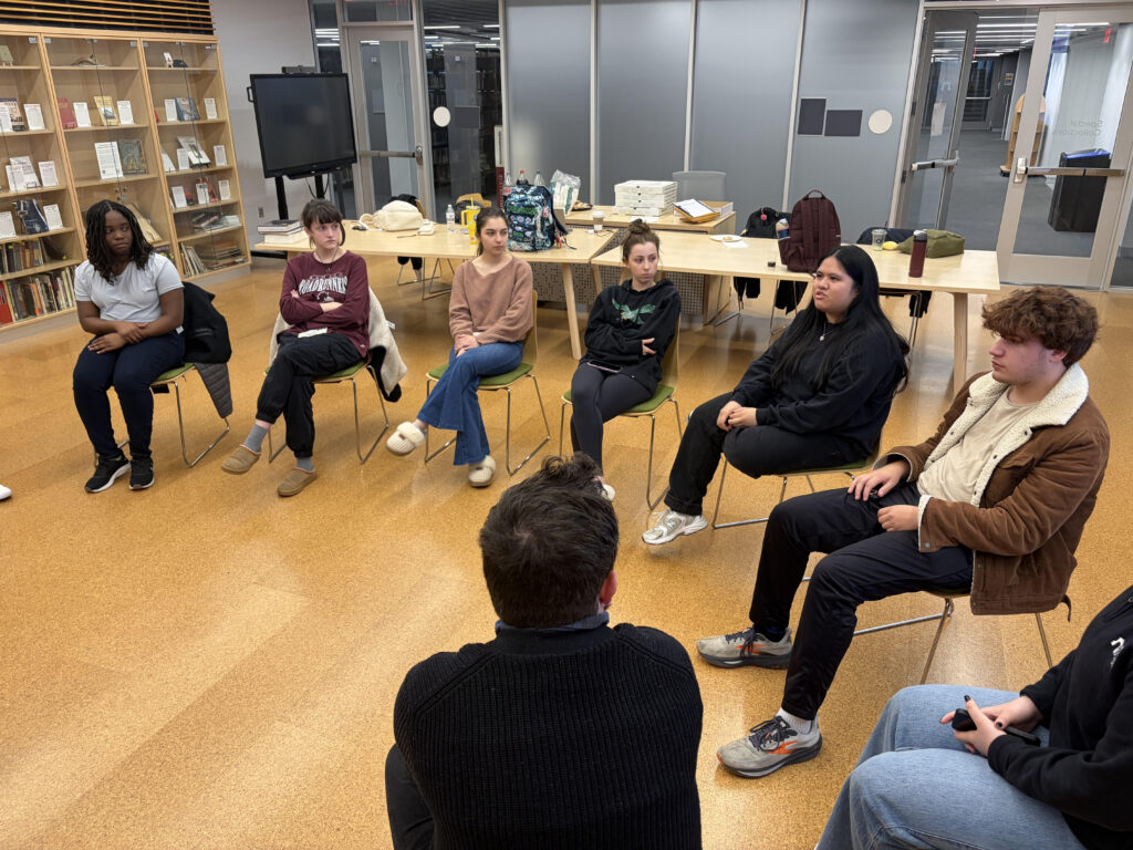 Students sitting in a half-circle engaged in discussion.
