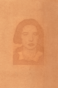 Anthotype portrait. It is a face rendered in an almost hazy fashion on a burnt orange square.