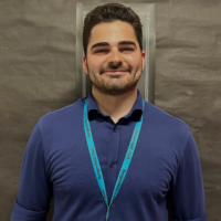 Richard's headshot in front of a black bulletin board.