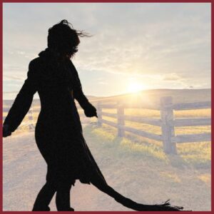 silhoutte of a women standing in front of a ranch scene