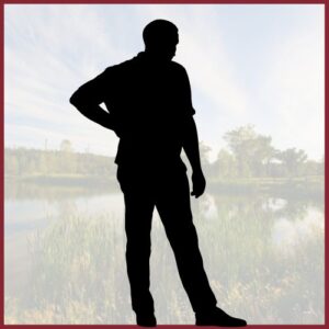 silhoutte of a man standing in front of marsh lands