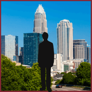 silhouette of a man standing with the background showing the skyline of Charlotte, North Carolina