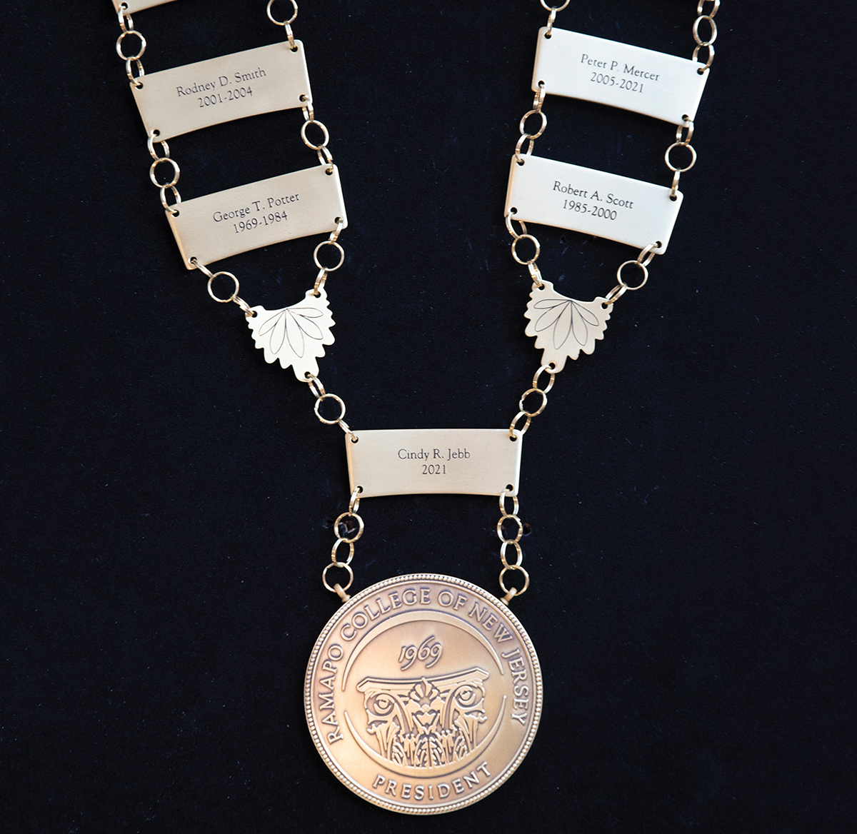 Silver chain with plaques that have RNCJ's past presidents on it, the Ramapo Seal and current president's name