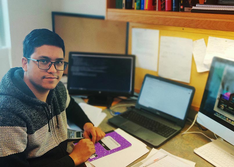 Student Subin Mali at his computer with his research