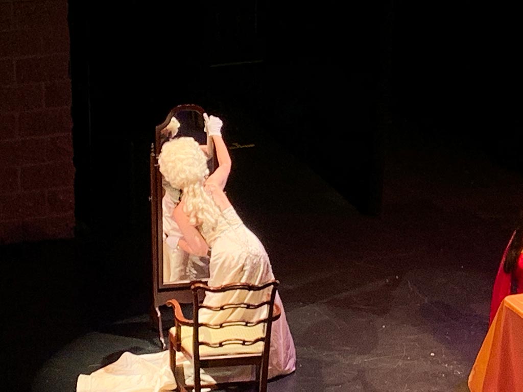 Actress on stage looking into mirror