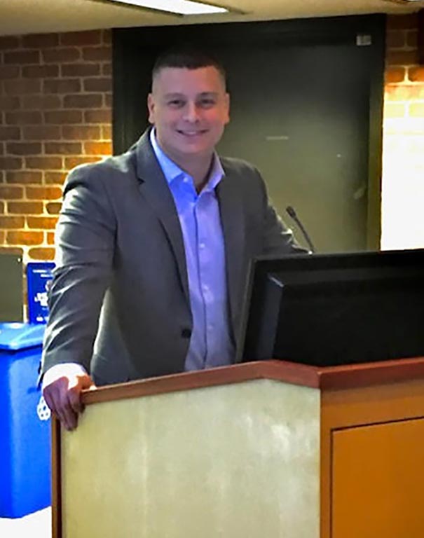 Kevin standing at a lectern 