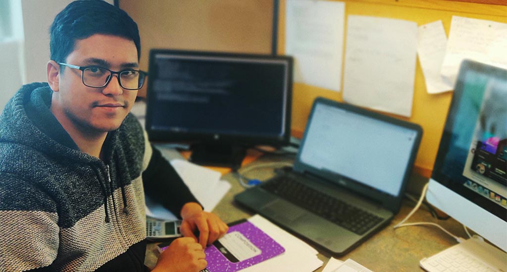 Student Subin Mali at his computer with his research