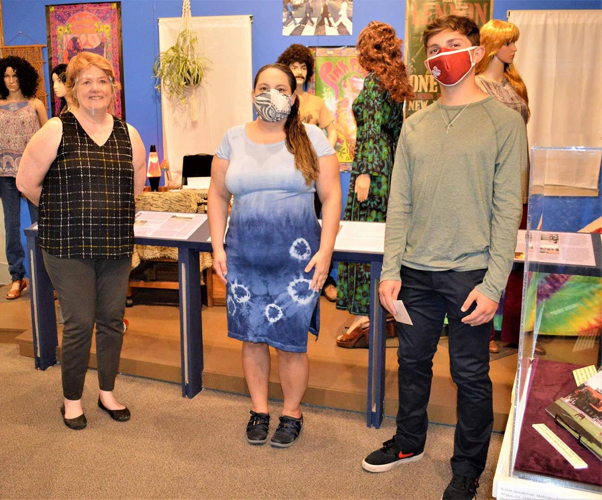 Three people stand in the Mahwah Museum
