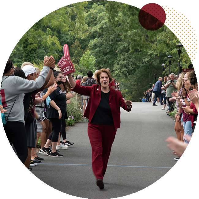 President Jebb cheers with a foam finger, down mansion road