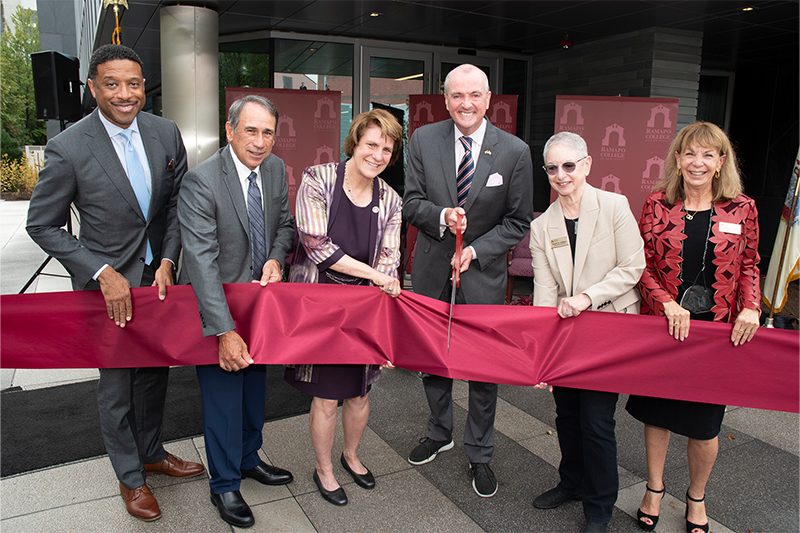 Participants cut ribbon in front of the Learning Commons