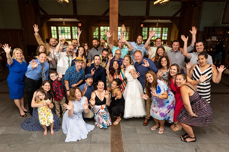 Group of people pose excitedly to celebrate a wedding