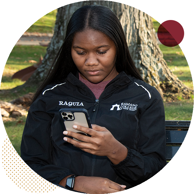 student sitting outside look at their phone