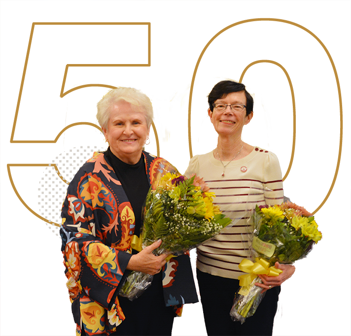 Friends of Ramapo's Margaret Mullen-Gensch (left) and Peggy Capomaggi (right) holding flowers in celebration of 50 years of the group