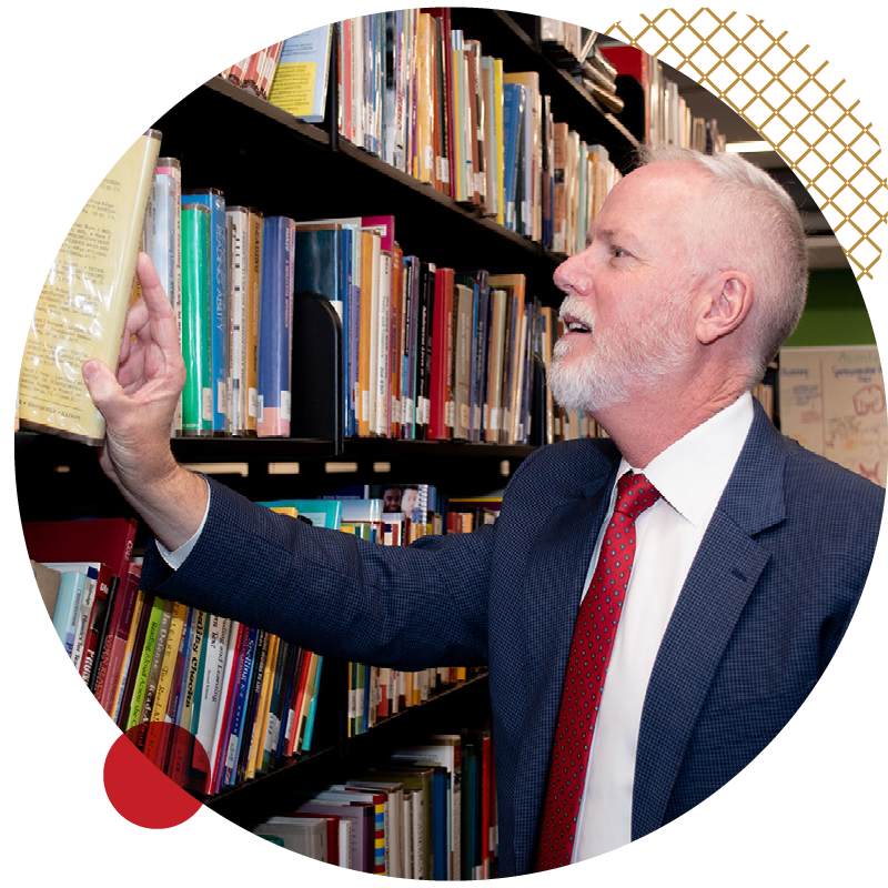 Michael Middleton grabbing a book from a book shelf