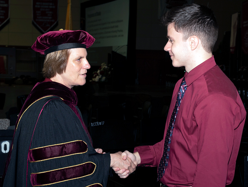 Jebb passes the Presidential Coin in a handshake.