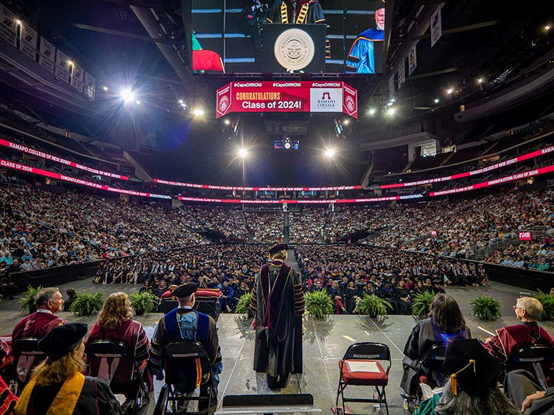 052924_00519_Ramapo_Commencement-LAROSA-web The back of Ramapo College's President Jebb in front of a large audience in the Prudential Center at Commencement