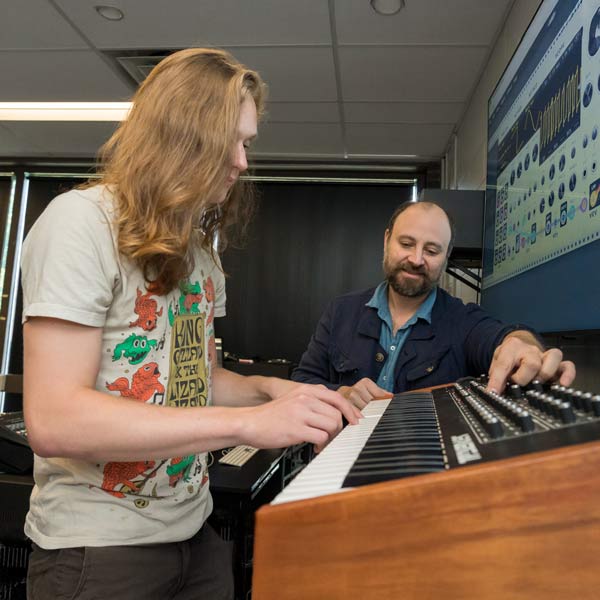 Ramapo College's associate professor of music Zach Layton works with a student, demonstrating sound design and synthesis techniques during a music production session.