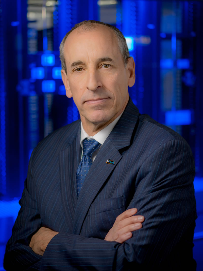 Ed Chapel ’77, wearing a suit with his arms crossed.