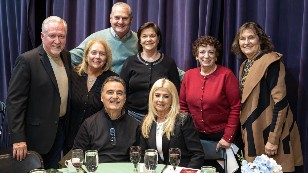 Group of guests behind a table smiling during the Foundation’s Performing Arts Dinner.