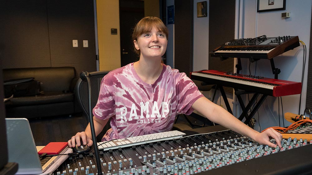 A Ramapo College student works at the mixing console in the Les Paul Studio, where students gain hands-on experience producing music in a professional recording environment.