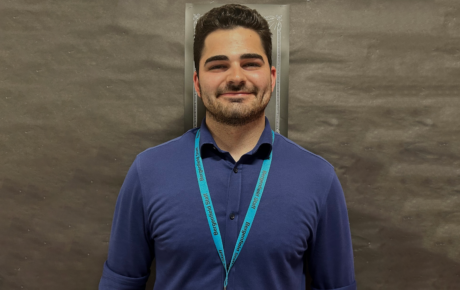 Richard's headshot in front of a black bulletin board.