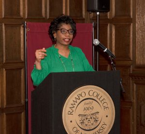 Dorine Bethea standing at a podium speaking