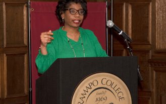 Dorine Bethea standing at a podium speaking