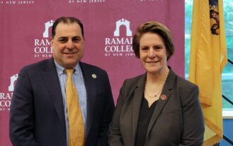 Senator Paul Sarlo and President Jebb pose in next to the NJ state flag