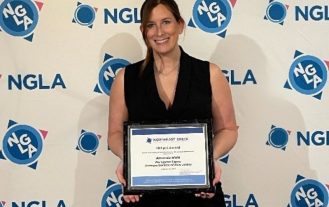 Amanda Riehl holds her Phillipi award in front of the NGLA step and repeat