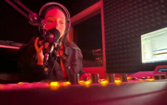 Student at sound board in radio station booth